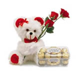 Sinfully delicious hazelnut chocolates being carried for your beloved by this cute teddy which says I miss you with these 3 red roses.
